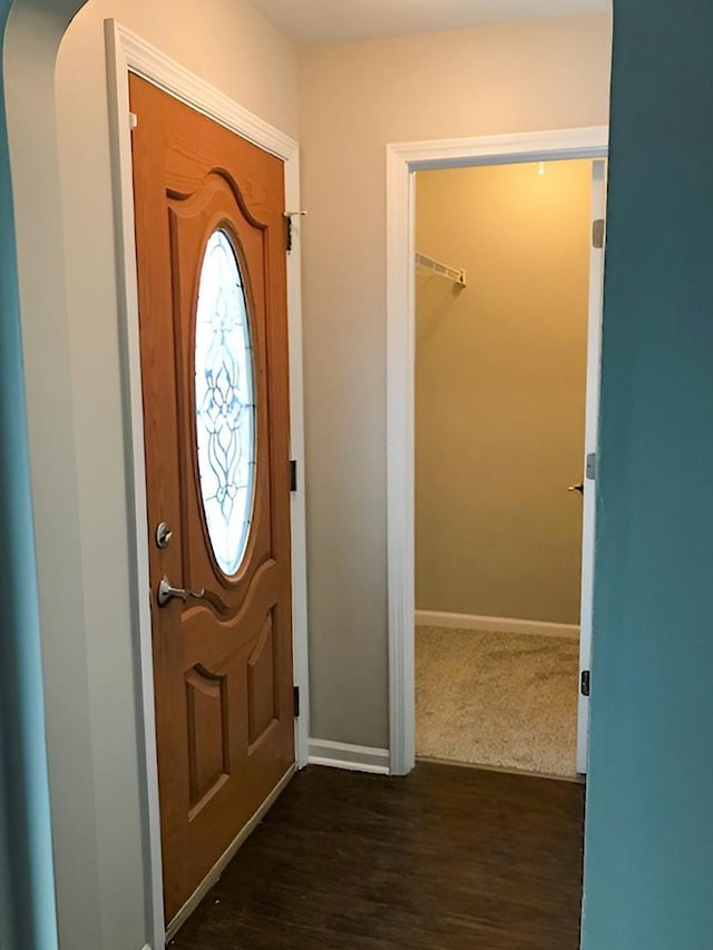 foyer featuring baseboards and dark wood-style flooring