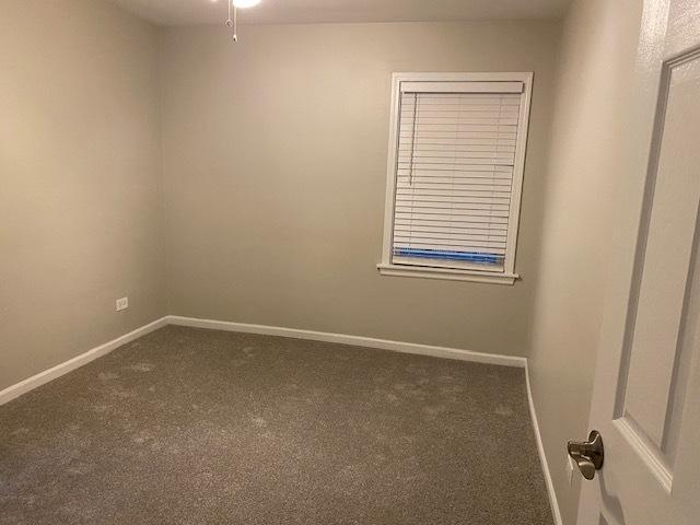 carpeted spare room featuring baseboards