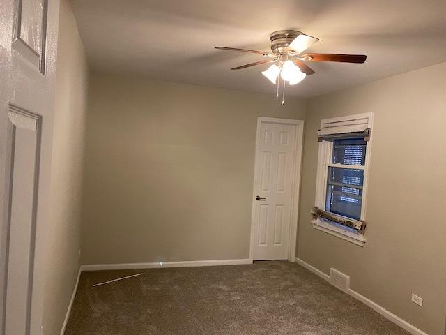 empty room featuring carpet, baseboards, and ceiling fan