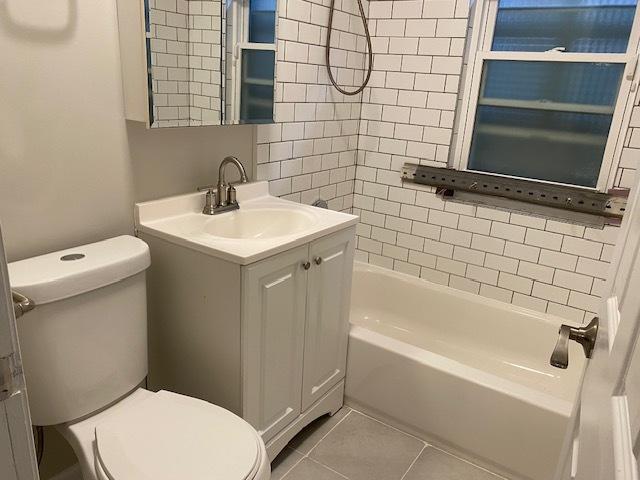 bathroom with  shower combination, tile patterned flooring, vanity, and toilet