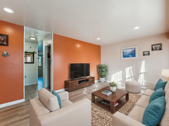 living area featuring baseboards, wood finished floors, and recessed lighting