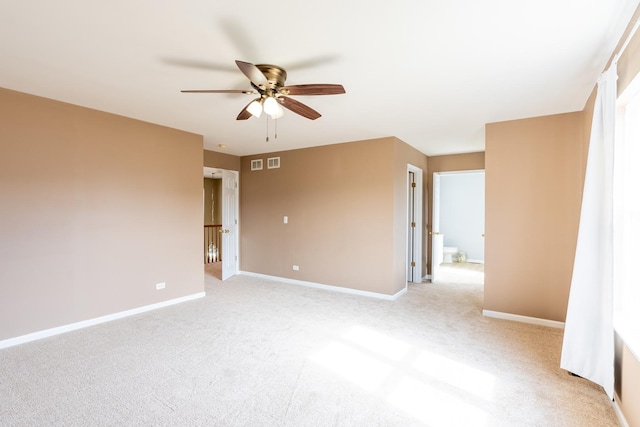 empty room with visible vents, baseboards, light colored carpet, and a ceiling fan