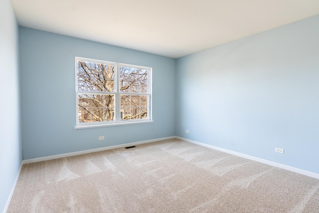 carpeted empty room featuring visible vents and baseboards