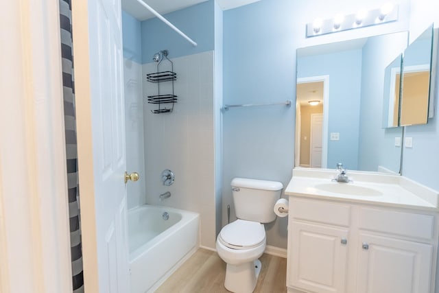 bathroom with vanity, toilet, wood finished floors, and  shower combination