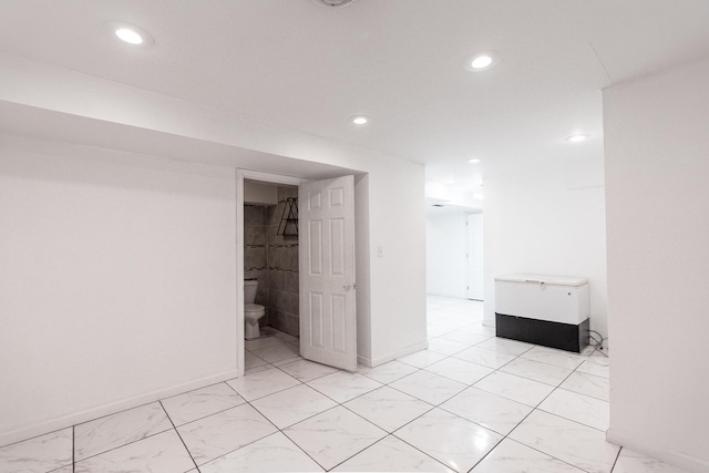 empty room featuring recessed lighting, baseboards, and marble finish floor