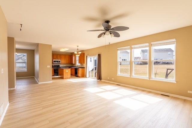 unfurnished living room featuring a ceiling fan, baseboards, visible vents, and light wood-type flooring