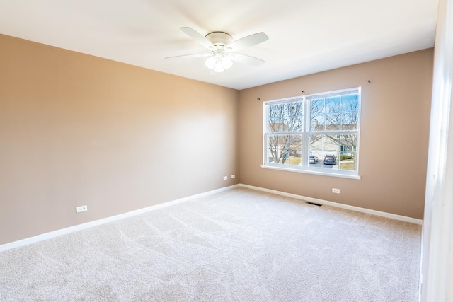 empty room featuring visible vents, carpet floors, baseboards, and ceiling fan