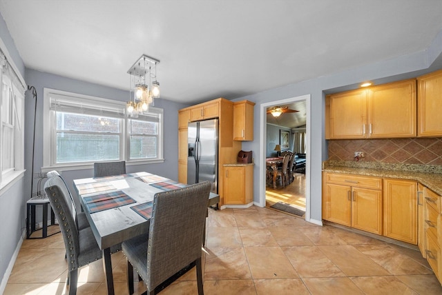 dining room featuring baseboards, a chandelier, and light tile patterned flooring