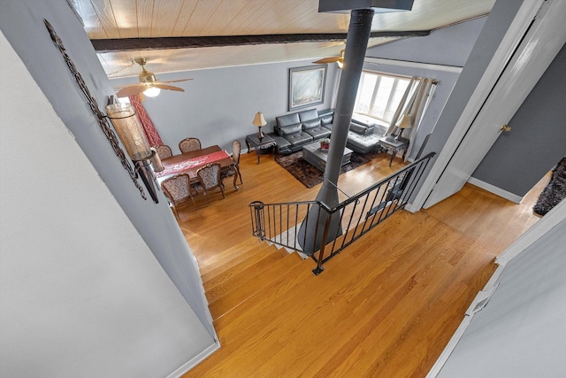 stairs with ceiling fan, wooden ceiling, vaulted ceiling with beams, and wood finished floors