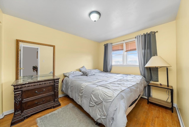 bedroom with baseboards and wood finished floors