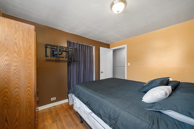 bedroom featuring wood finished floors and baseboards