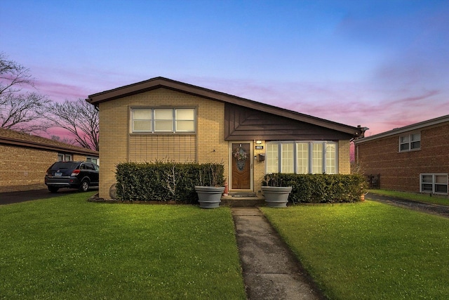 tri-level home featuring a front yard and brick siding