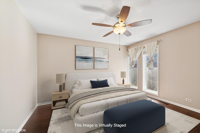 bedroom featuring a ceiling fan, visible vents, dark wood finished floors, and baseboards