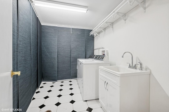 laundry area with laundry area, a sink, independent washer and dryer, and light floors