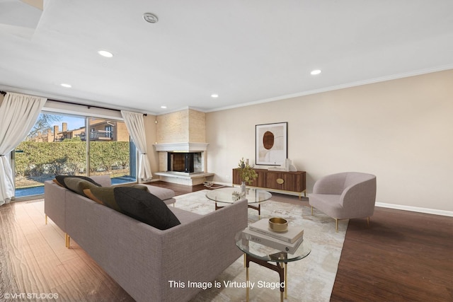 living room featuring recessed lighting, ornamental molding, a multi sided fireplace, wood finished floors, and baseboards