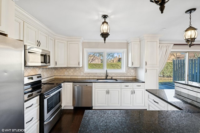 kitchen with white cabinets, appliances with stainless steel finishes, dark wood-type flooring, decorative light fixtures, and a sink