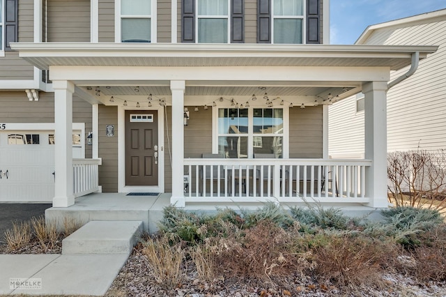 view of exterior entry with a garage and covered porch