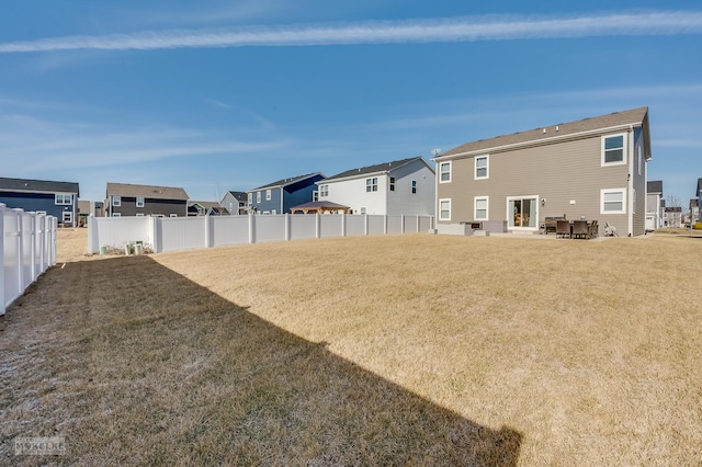 view of yard featuring a patio area, a residential view, and fence