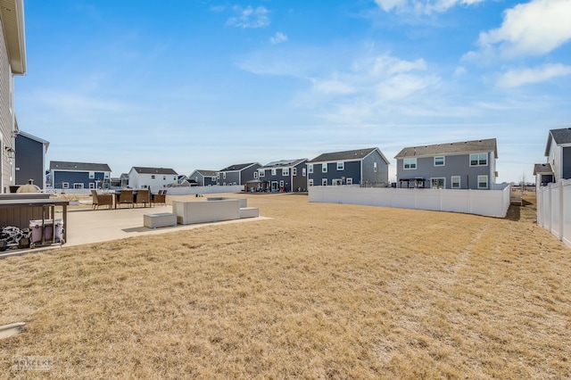 view of yard featuring a patio area, a residential view, and fence