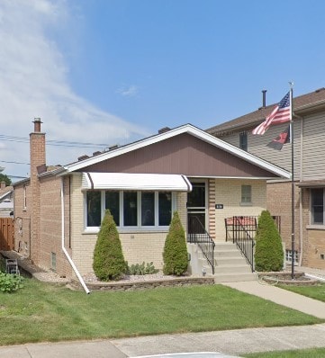 view of front of home featuring a front lawn and brick siding