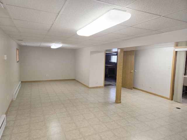 finished below grade area featuring light floors, baseboards, and baseboard heating