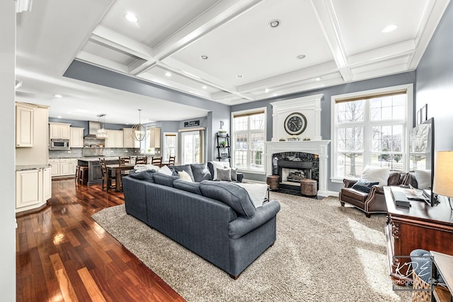 living room featuring a fireplace, coffered ceiling, dark wood-type flooring, and beamed ceiling