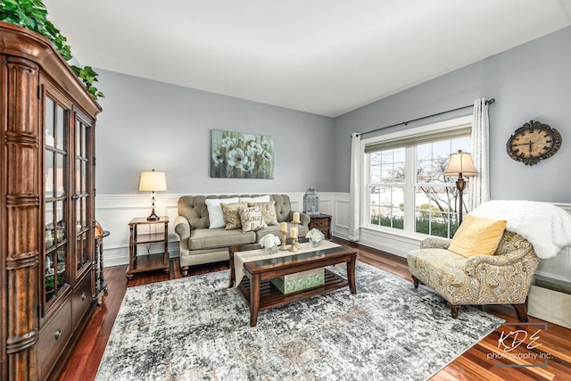 living area featuring dark wood-type flooring and wainscoting