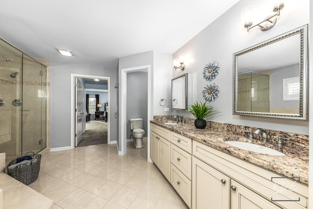 bathroom featuring toilet, a shower stall, double vanity, and a sink