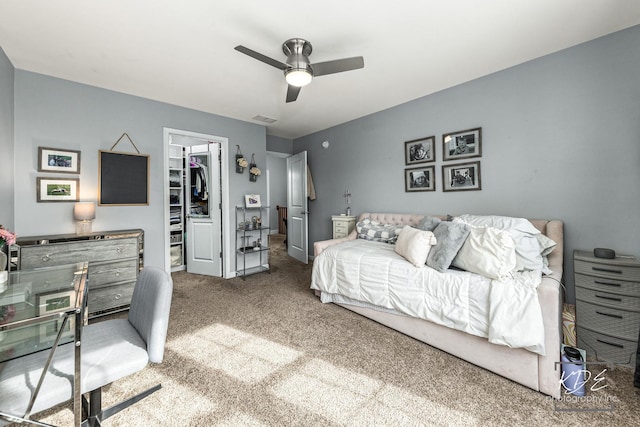 bedroom featuring a walk in closet, a closet, visible vents, a ceiling fan, and carpet flooring