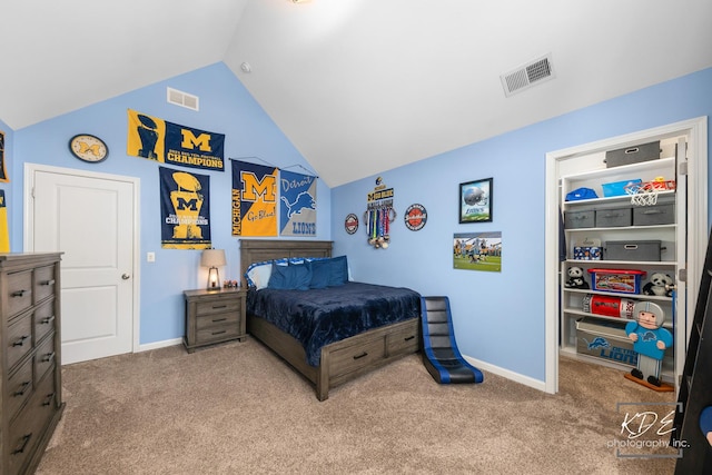 bedroom with carpet floors, lofted ceiling, and visible vents