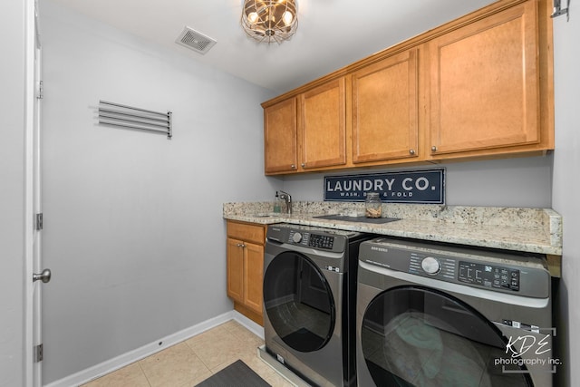 laundry room featuring cabinet space, light tile patterned floors, visible vents, baseboards, and washing machine and dryer