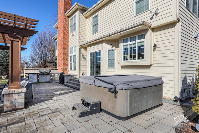 view of patio featuring a hot tub, grilling area, and a pergola