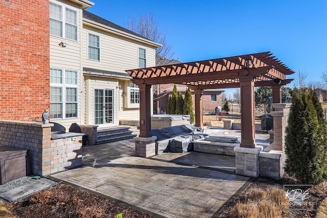 view of patio featuring exterior kitchen, a hot tub, and a pergola