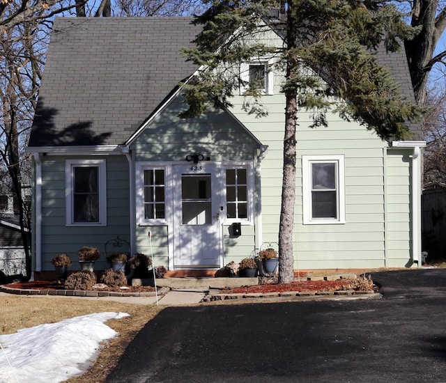 new england style home featuring a shingled roof