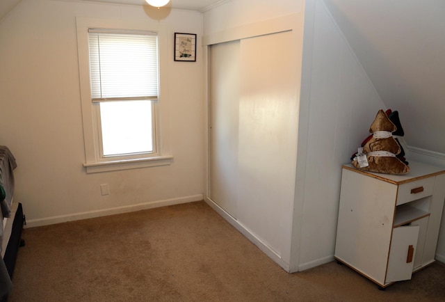 unfurnished bedroom featuring lofted ceiling, light carpet, and baseboards