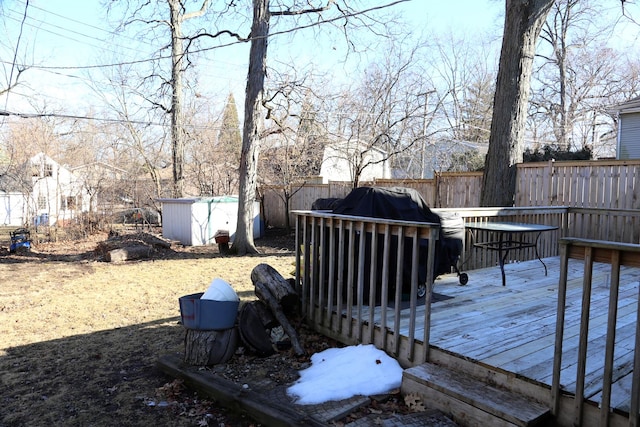 deck featuring a storage unit and a fenced backyard