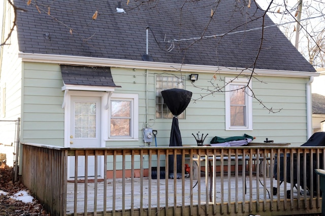 back of property with a deck and a shingled roof