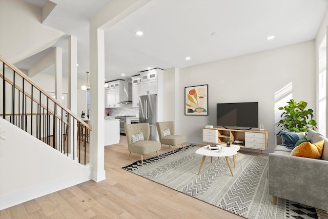 living room with stairs, light wood-style flooring, and recessed lighting