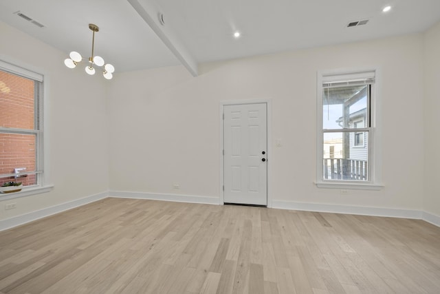 spare room with beam ceiling, a notable chandelier, visible vents, light wood-style flooring, and baseboards