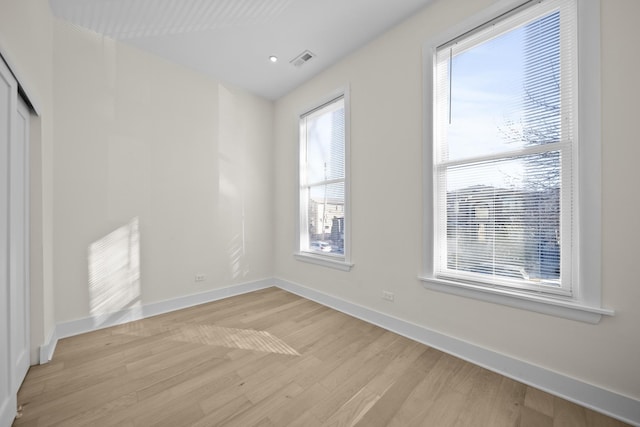 interior space featuring light wood-type flooring, visible vents, and baseboards