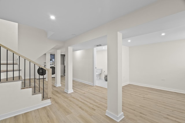 finished below grade area featuring baseboards, light wood-style flooring, washer / clothes dryer, stairs, and recessed lighting