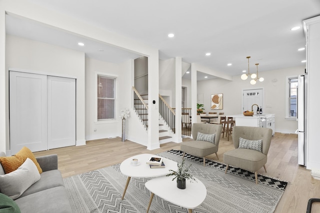 living room featuring light wood-style floors, baseboards, stairway, and recessed lighting