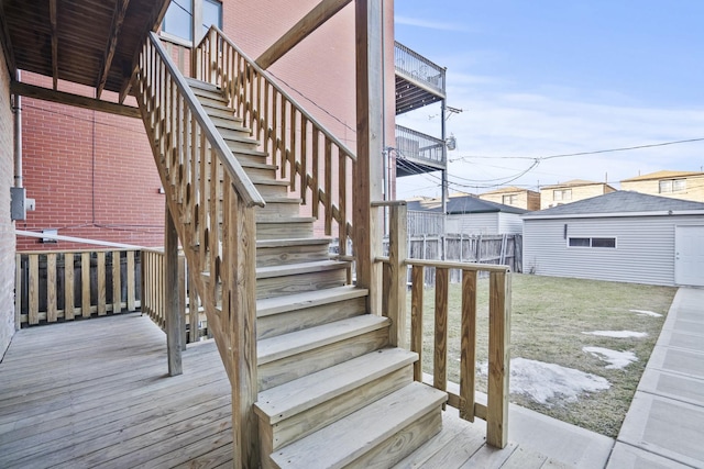 wooden terrace featuring stairway and a lawn