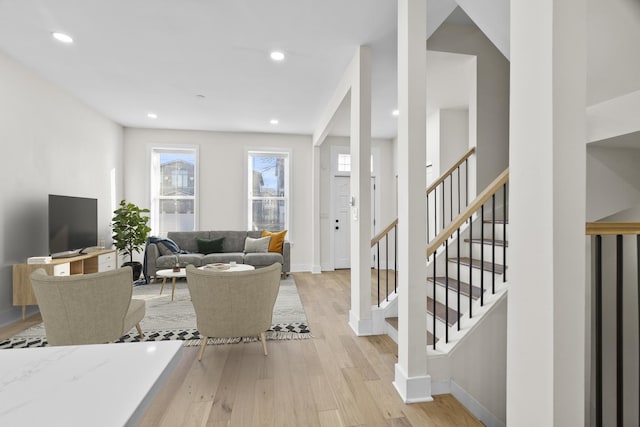 living room with light wood-style floors, recessed lighting, stairway, and baseboards