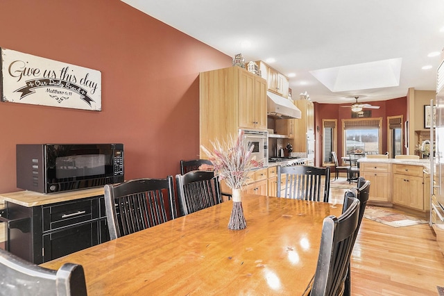 dining room featuring light wood-type flooring, a fireplace, a ceiling fan, and recessed lighting