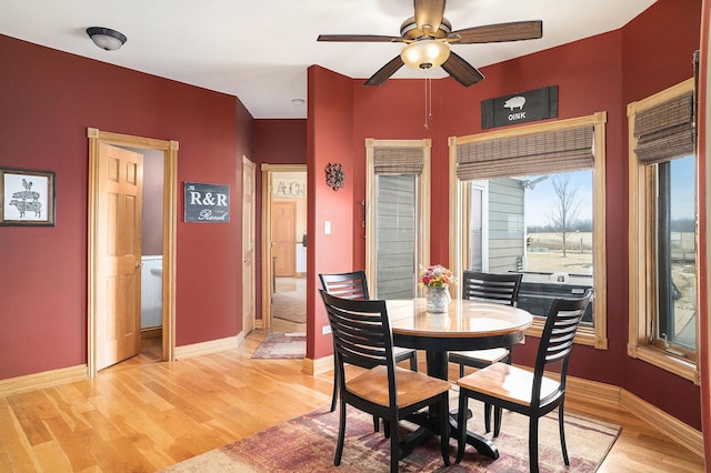 dining area featuring light wood-type flooring, baseboards, and a ceiling fan