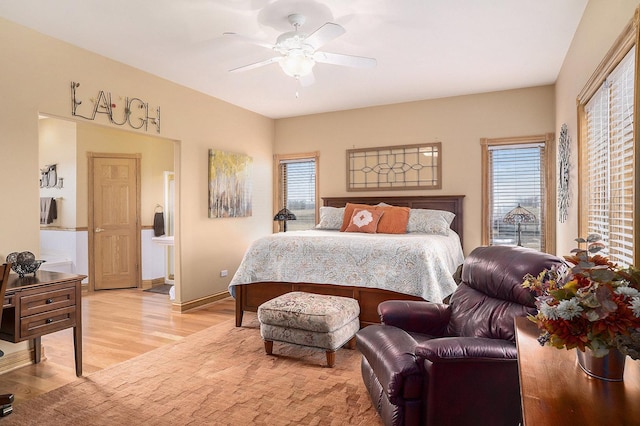 bedroom featuring baseboards, connected bathroom, a ceiling fan, and light wood-style floors