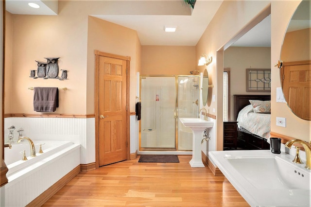 bathroom featuring a garden tub, ensuite bath, wood finished floors, and a shower stall