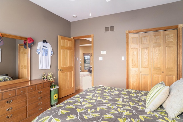 bedroom featuring visible vents, a closet, and wood finished floors