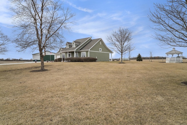 view of side of property featuring a lawn and a gazebo